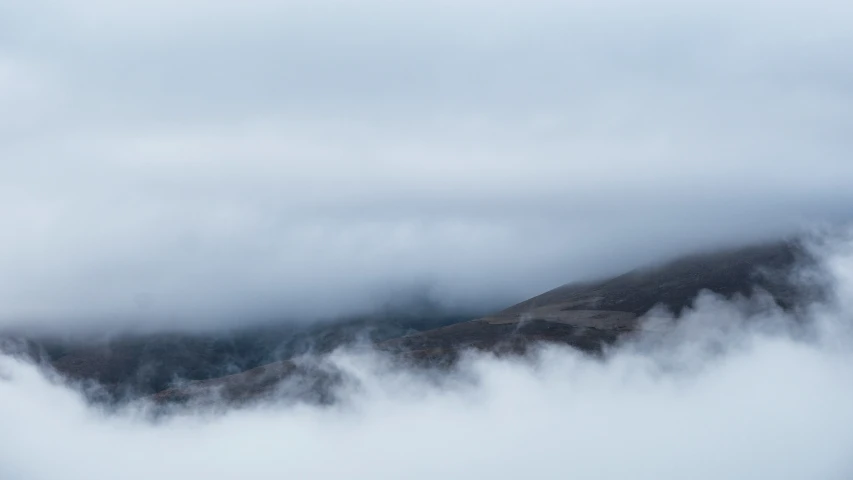 a mountain covered in clouds in the distance