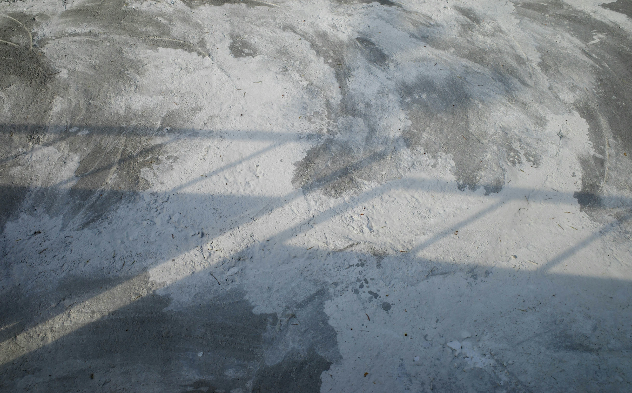 shadows and textures on the cement of a street