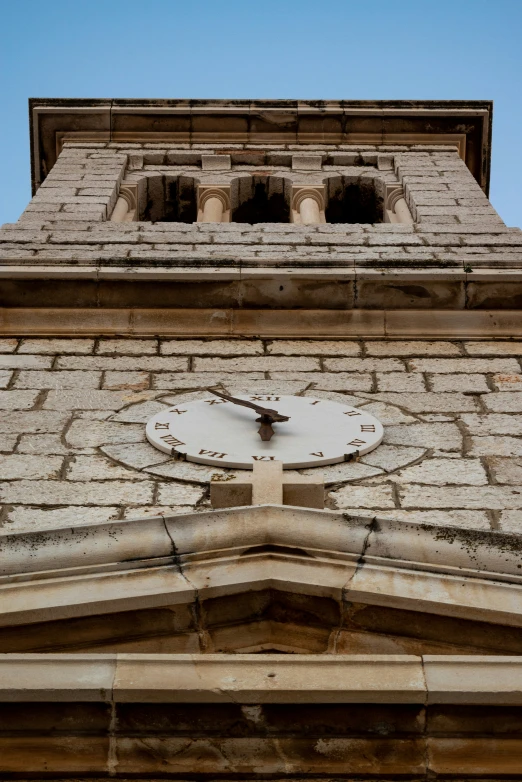 there is an old clock that has been built in the side of a building