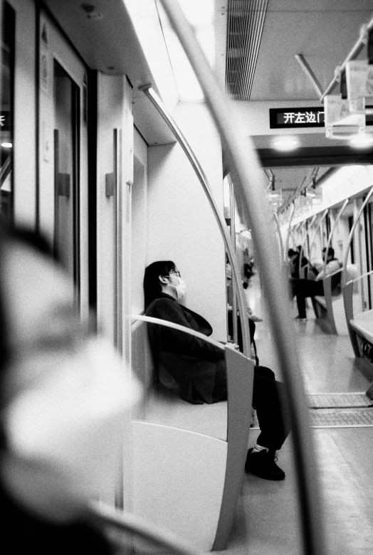 black and white po of a man sitting on the subway