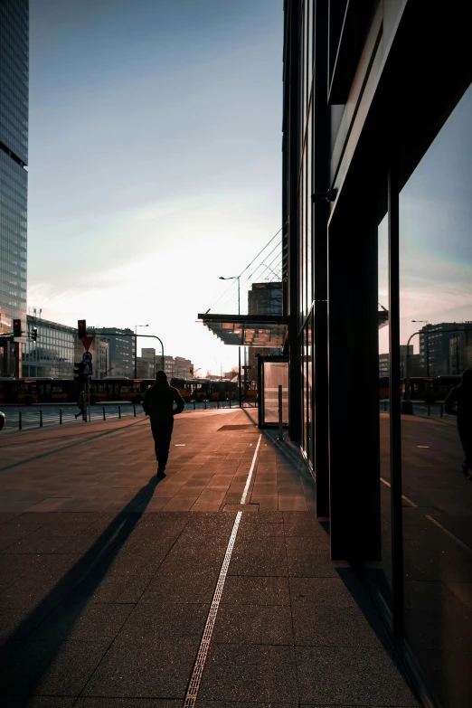 people walk down the sidewalk next to a building