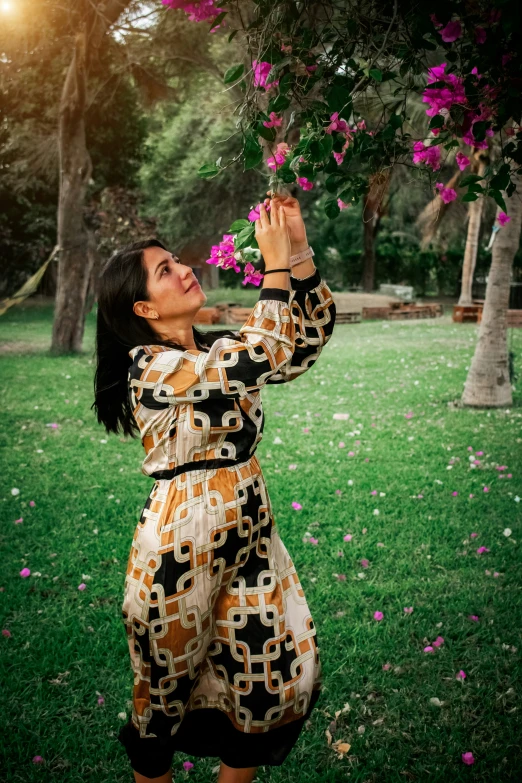 a young woman holding onto a purple flower