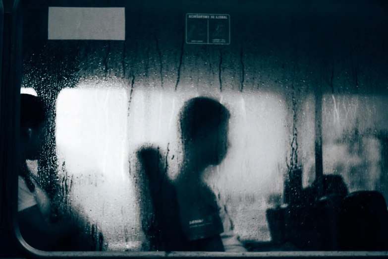 a person in front of a rain covered window