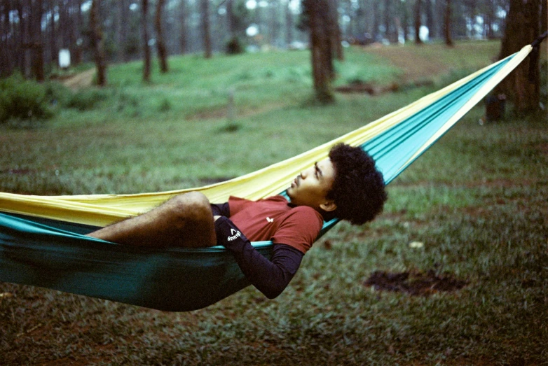 a man is laying in a hammock and smiling