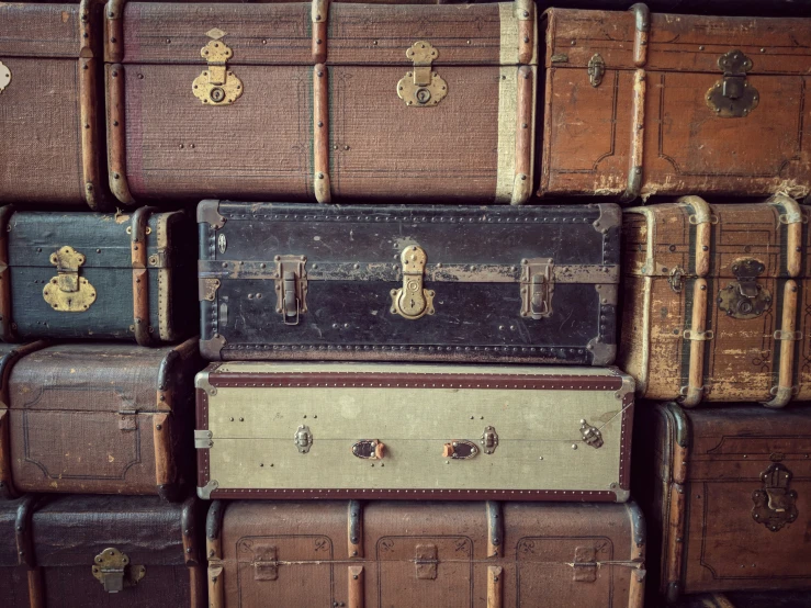 a large pile of suitcases with gold handles