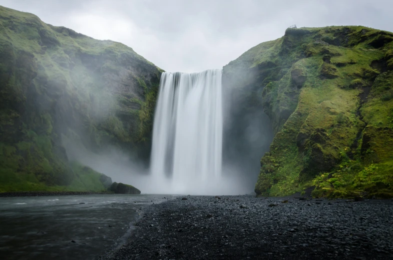 a very tall waterfall pouring out of the middle of a river