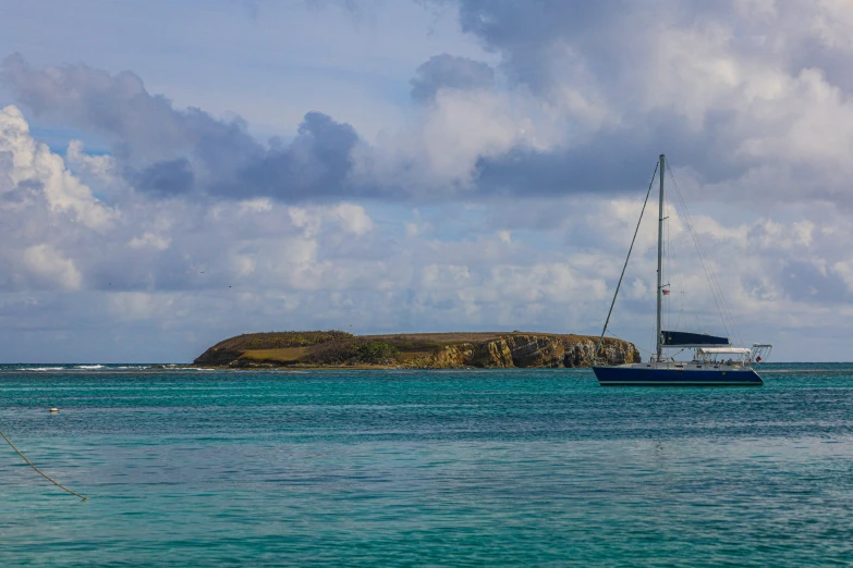 there is a sailboat anchored off a island