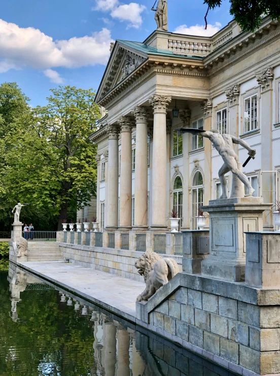 a stone statue with a fountain outside of a building