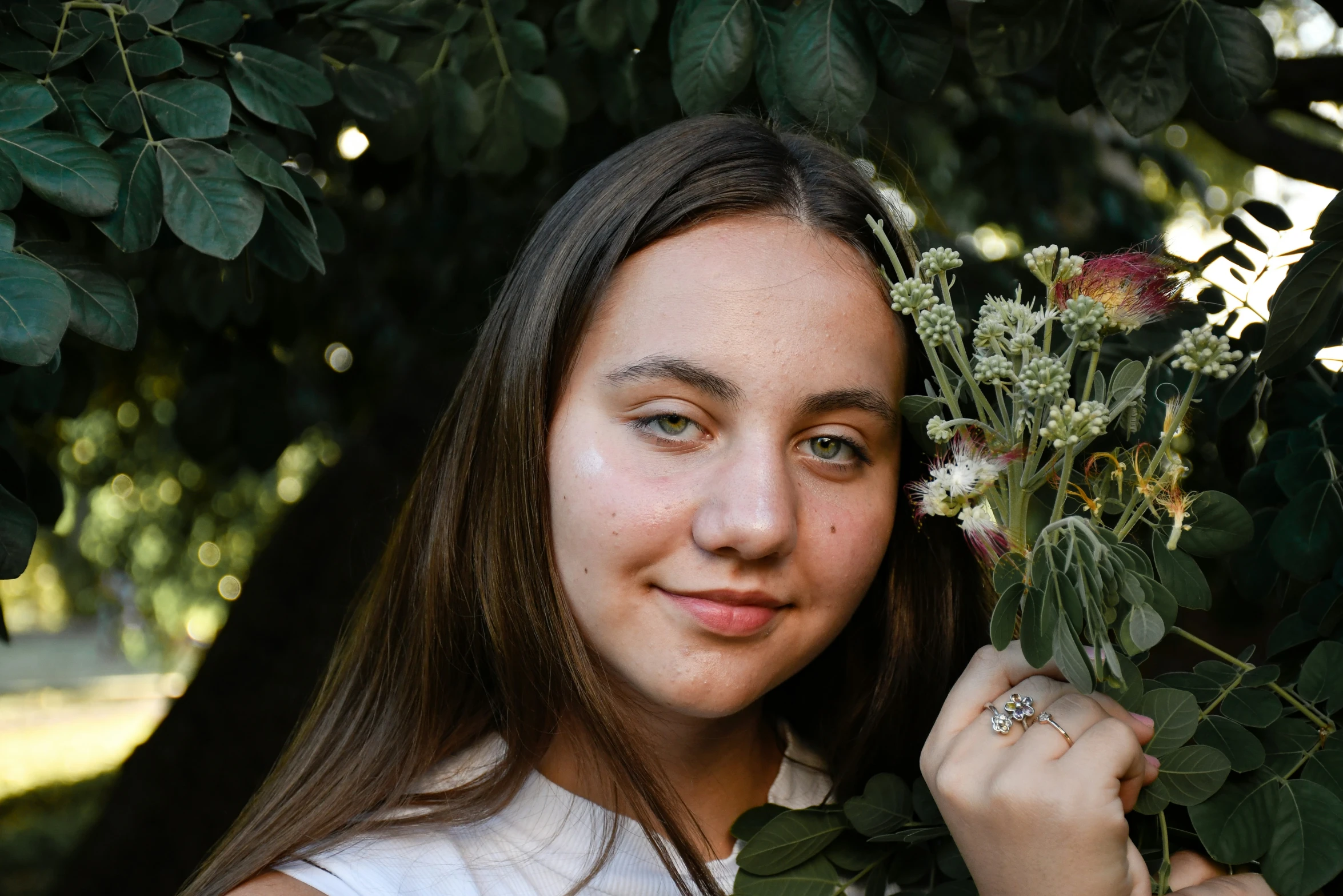 girl is smiling, holding onto a flower