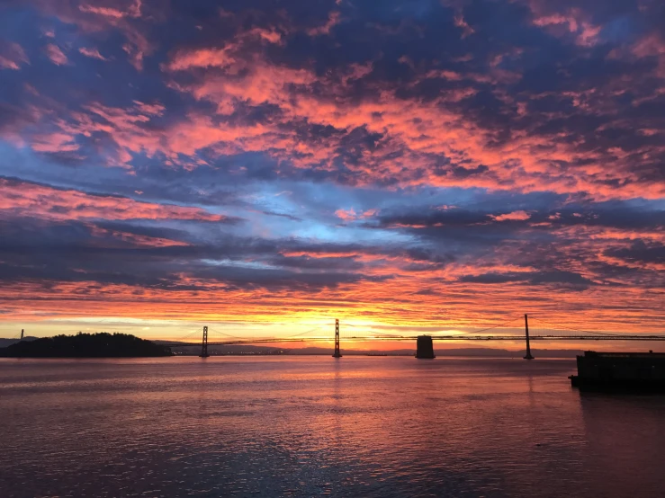 a sunset and some very pretty clouds above the water