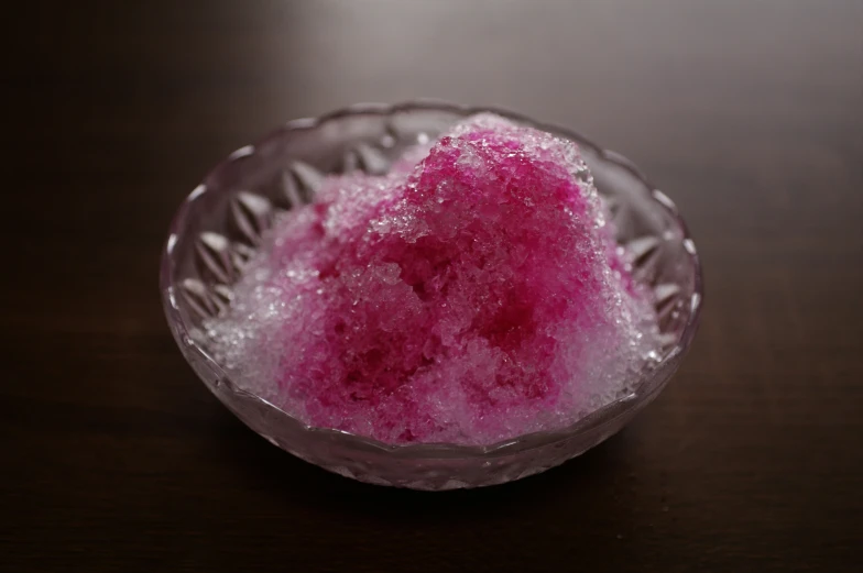a small glass bowl with a pink substance inside