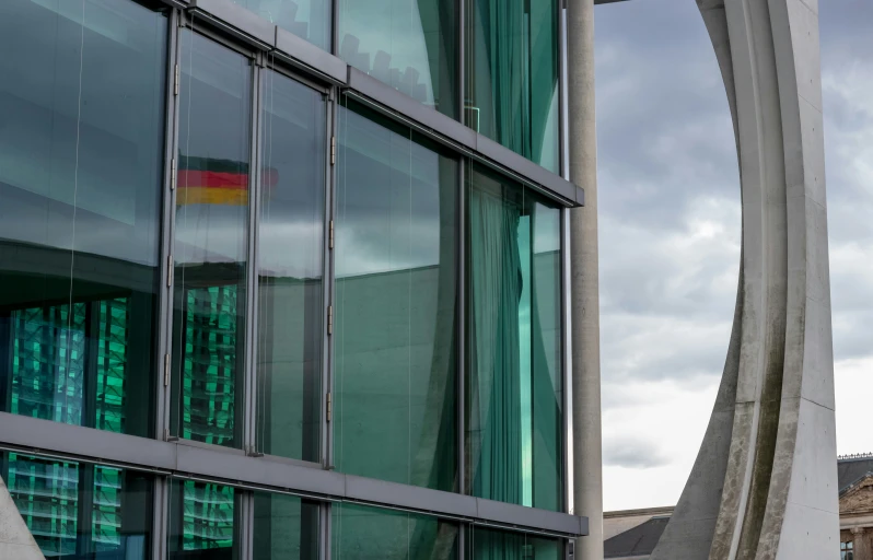 a clock that is in front of a glass building