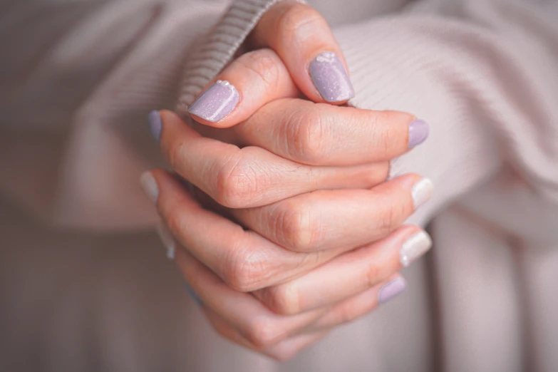 a woman with two hands together holding a small pink object