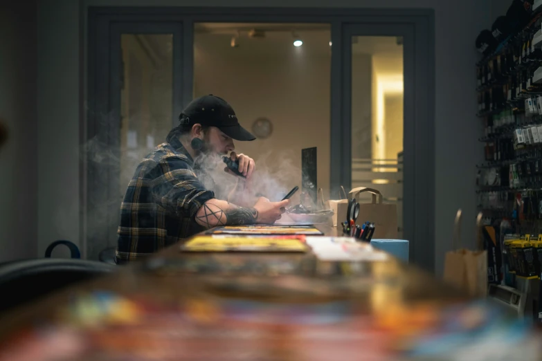 man smoking on cell phone in kitchen area