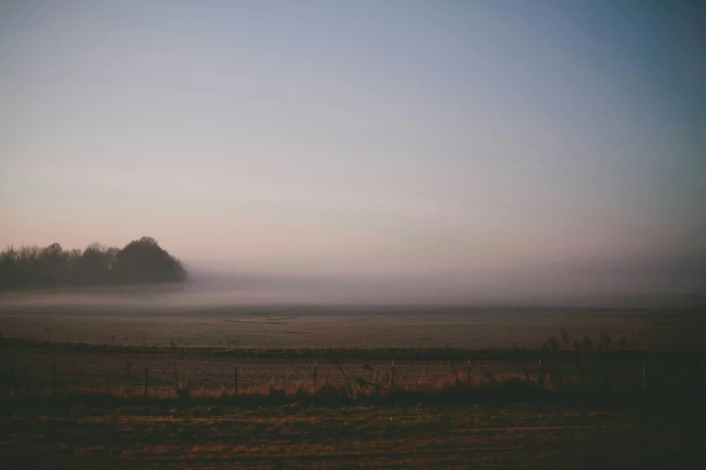 an image of fog in the sky over a field