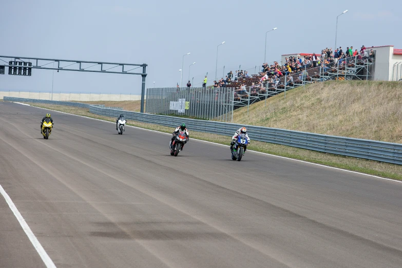 three people on motorcycles driving down the road