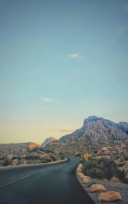 an asphalt road leading into the mountains