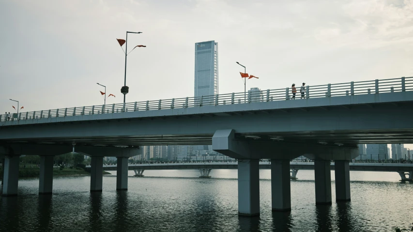 people are standing on the walkway over the water