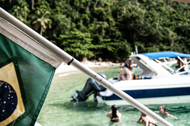 people on the beach next to boats with zil flag waving