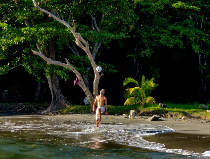 a man that is playing with a ball in the water