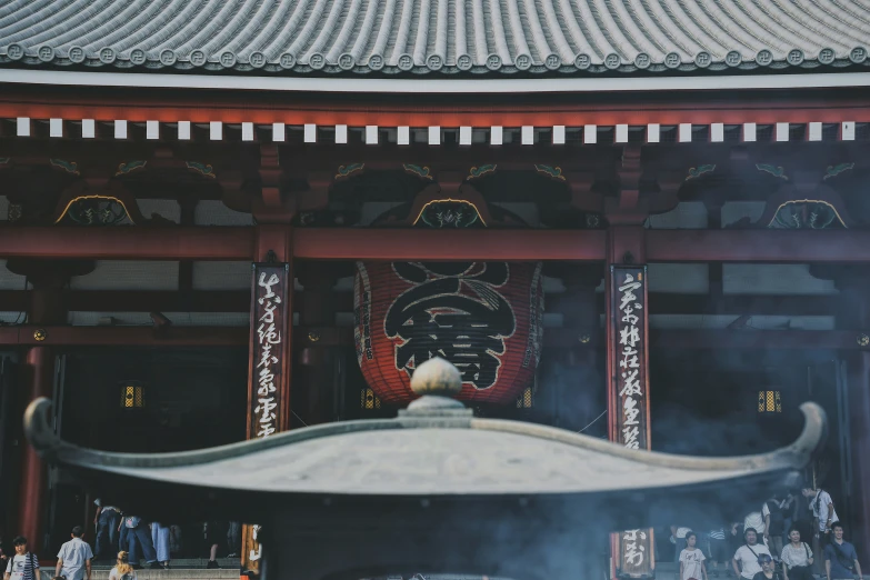 an asian architecture in the sunlight with lots of people