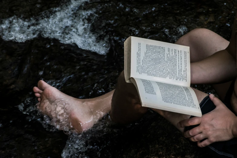 the person has very bare feet and reads a book