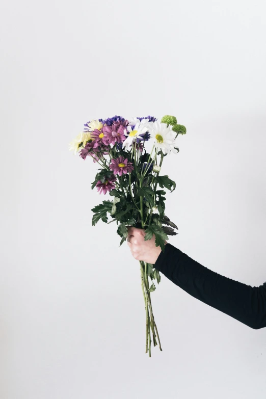 woman holding a bouquet of flowers against a white background