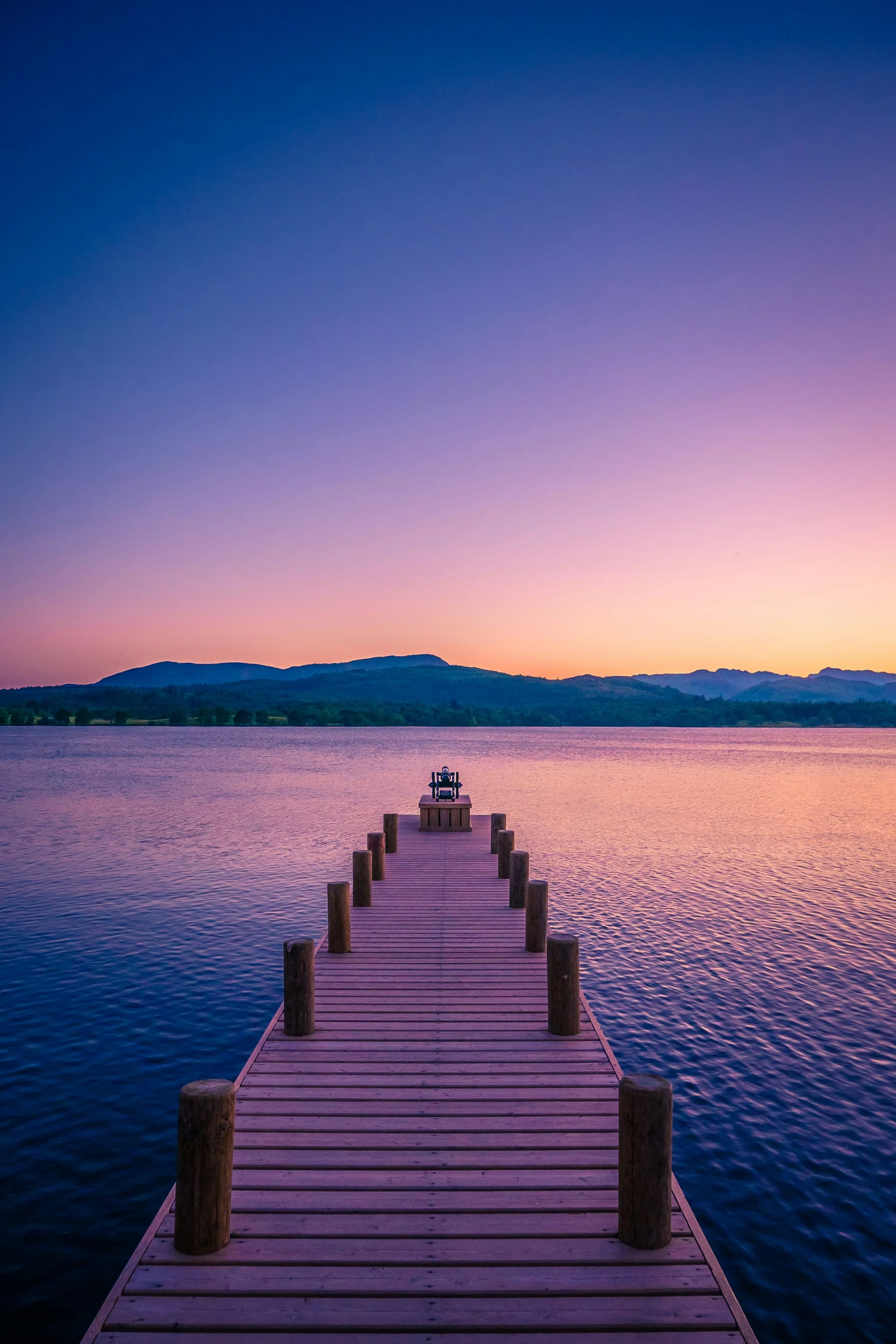 this is a view of a pier in the ocean at sunset