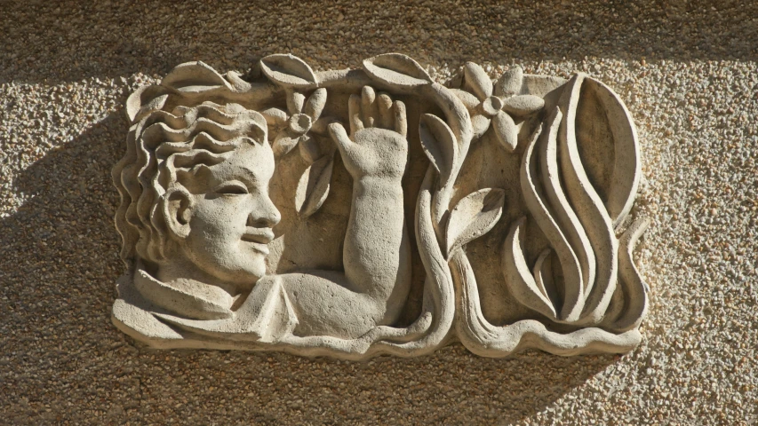 a carving of a woman's head holding leaves