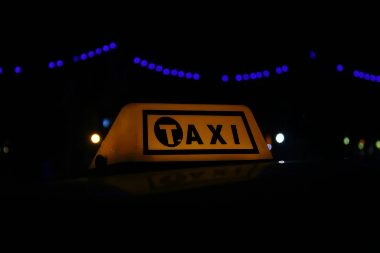 a street sign that says taxi on it in the dark