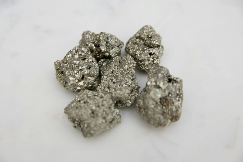 some silver rocks sitting on a white marble counter top