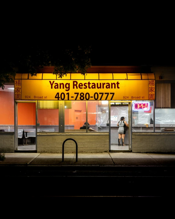 a person is walking by a storefront at night