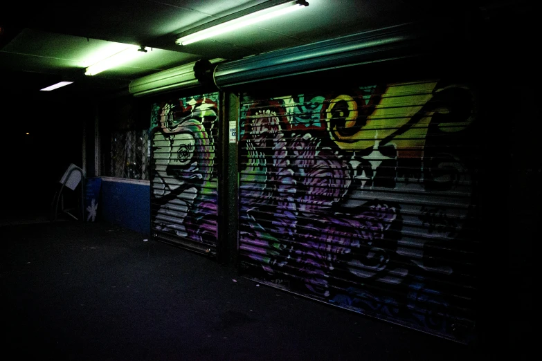 a wall with graffiti is lit up by a street light
