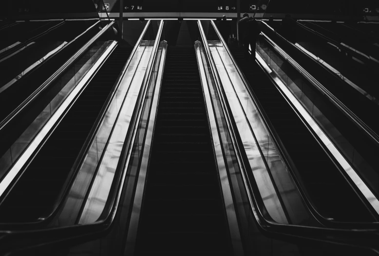 black and white pograph of escalators looking upward