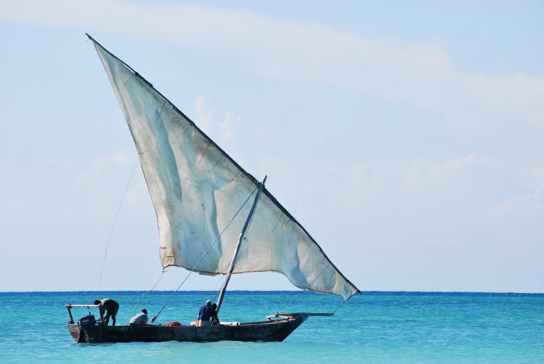 two men in a small sail boat in the ocean