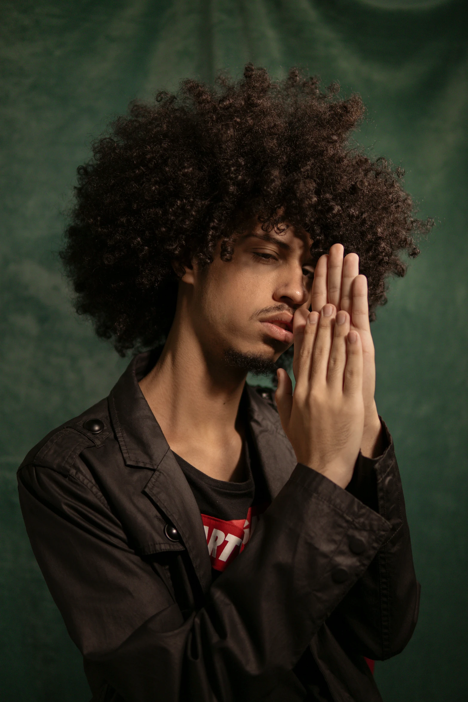 the young man is holding his hands up to his face