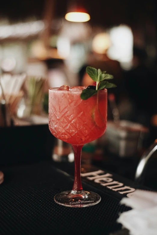 a close up of a pink cocktail in a glass