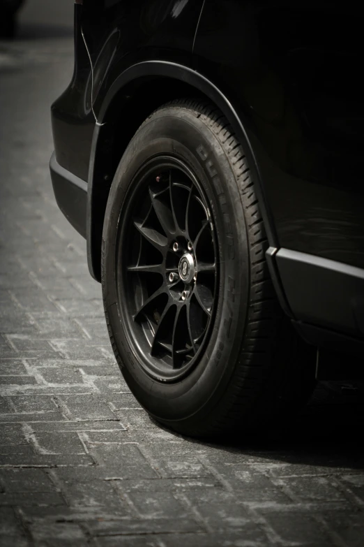 the wheel on a black car on a cobble stone floor