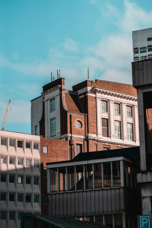 many buildings against a blue sky and some clouds