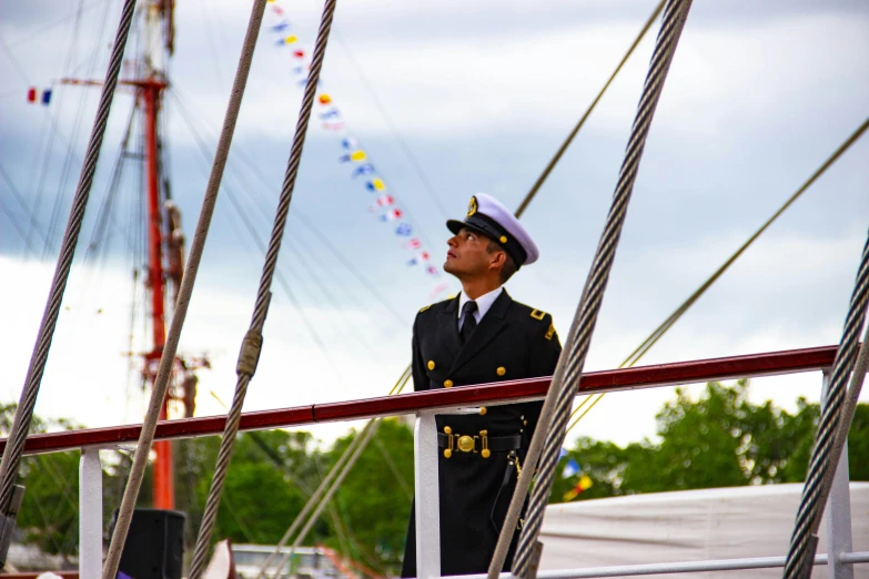 a man in uniform is standing on a sailboat