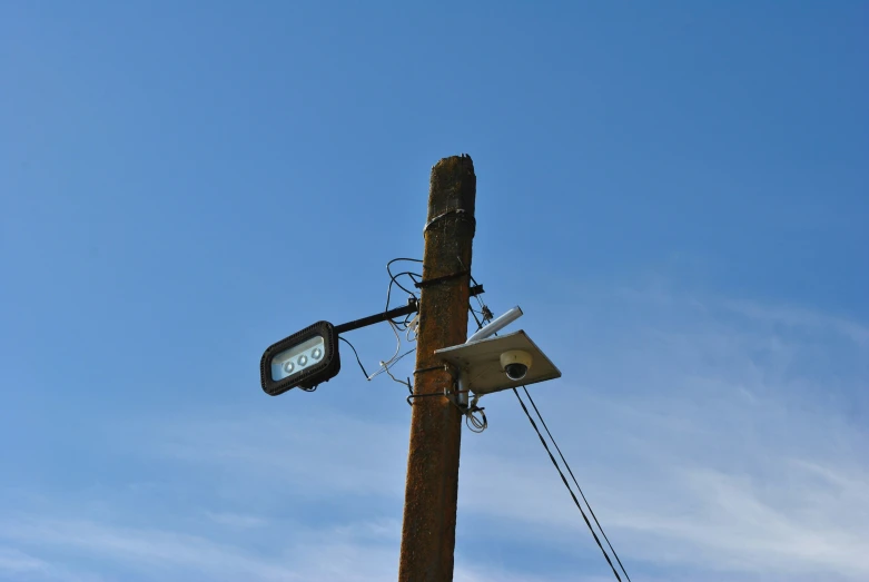 a stop light attached to a pole against a clear sky