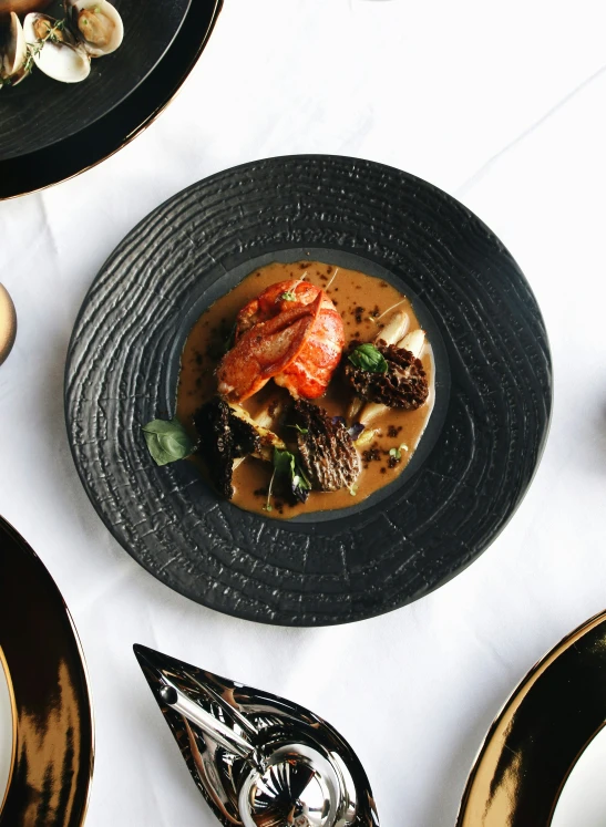 plated food with spoon and plate near it on top of cloth