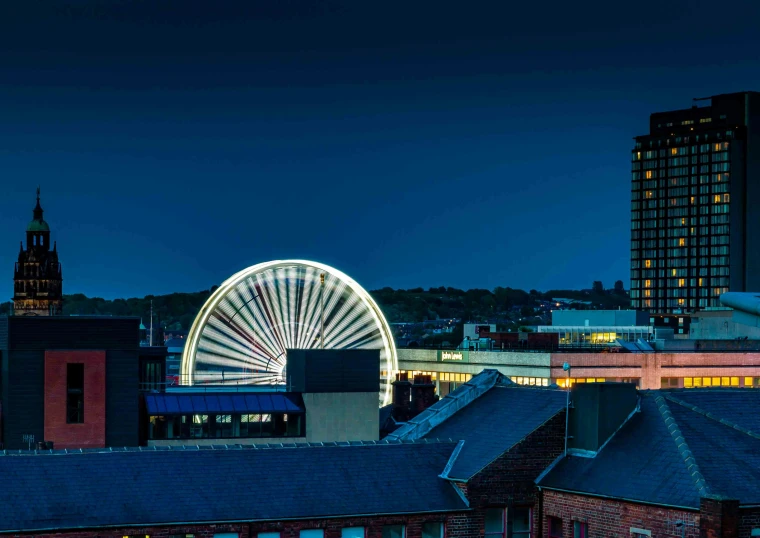 a ferris wheel on top of a building near buildings