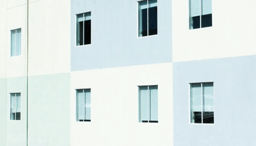 a grey building that has windows with white frames