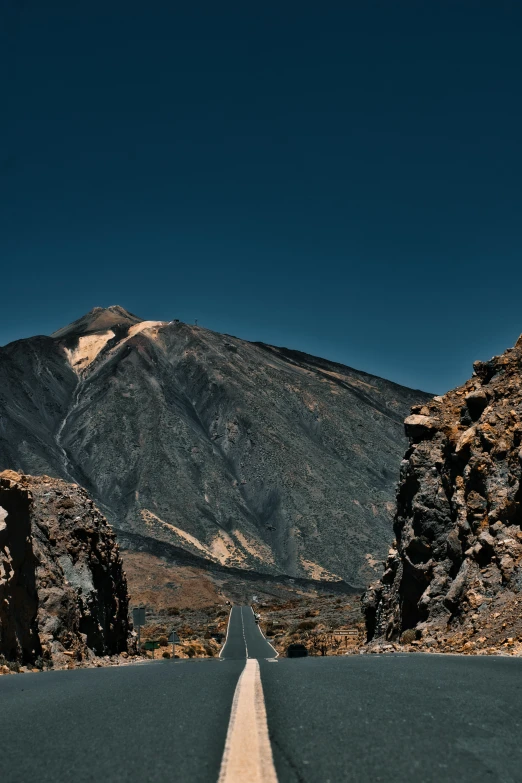 a large road near mountains and a blue sky