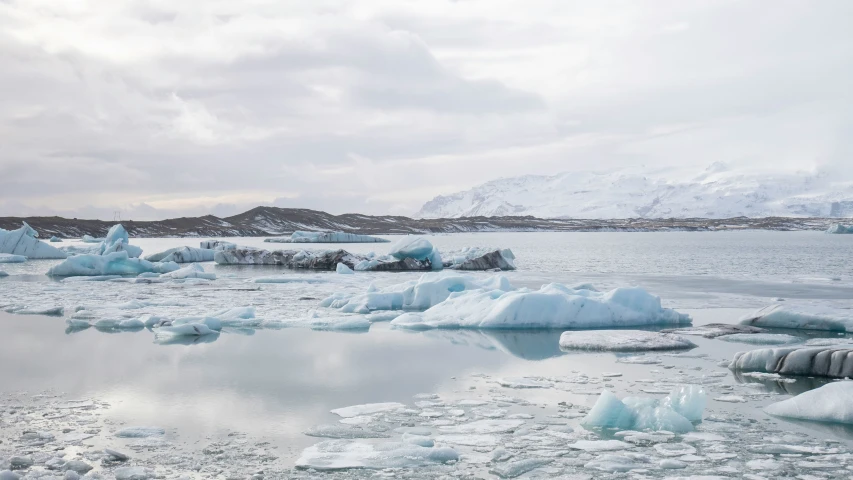 a lake filled with icebergs surrounded by mountains