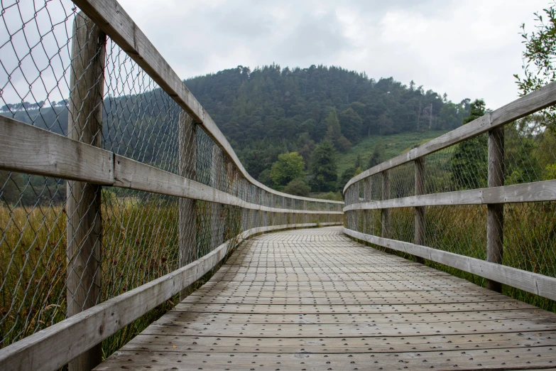 a bridge with a brick walkway and barbed wire