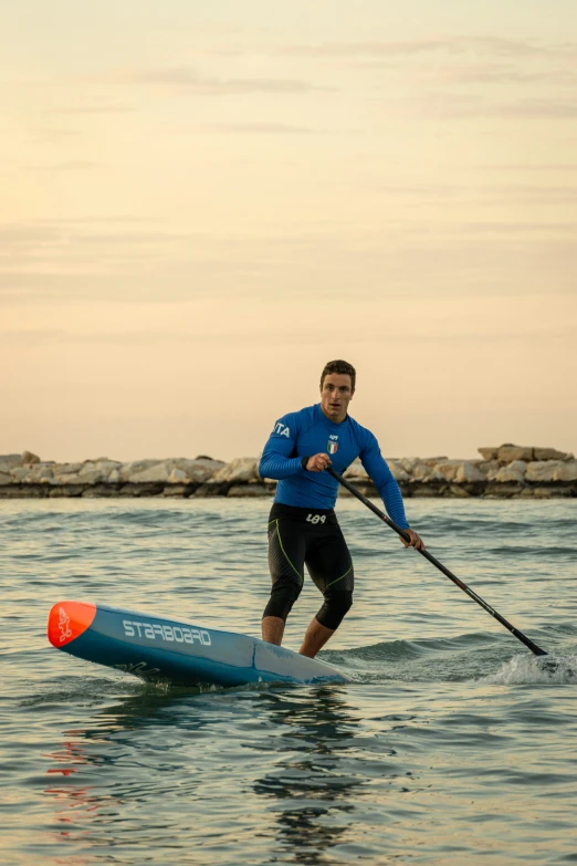 the man is paddle boarding in the water