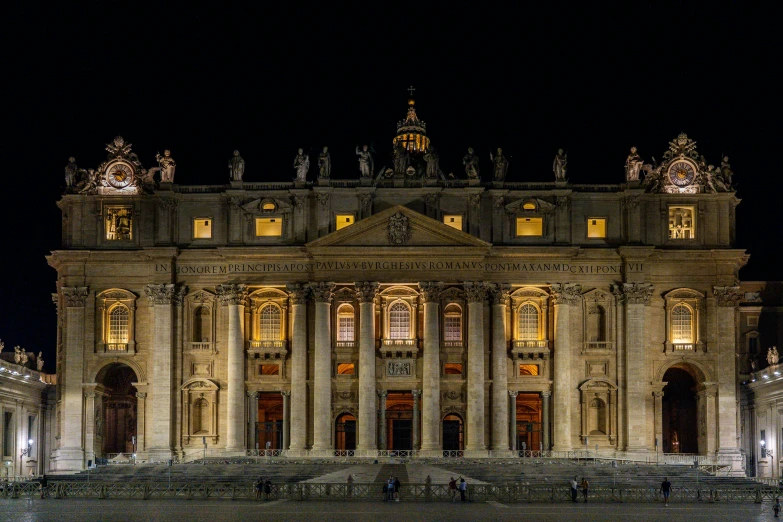 people are gathered at the base of the palace in the night