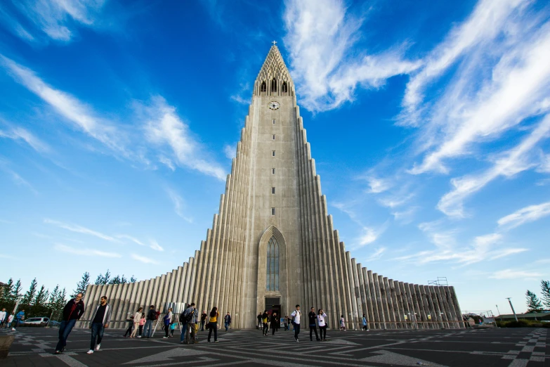 people standing in front of a tall tower with clocks